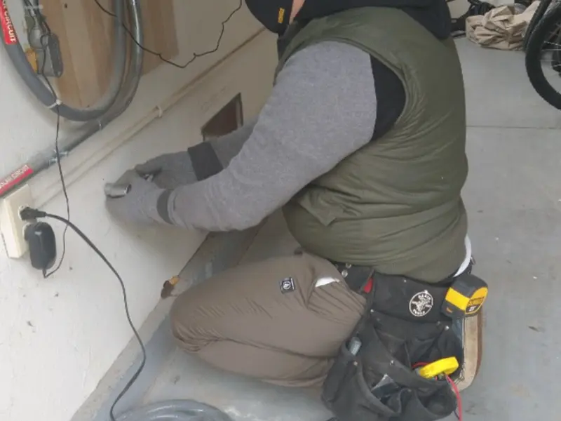 Electrician performing outlet wiring in a Daleville garage